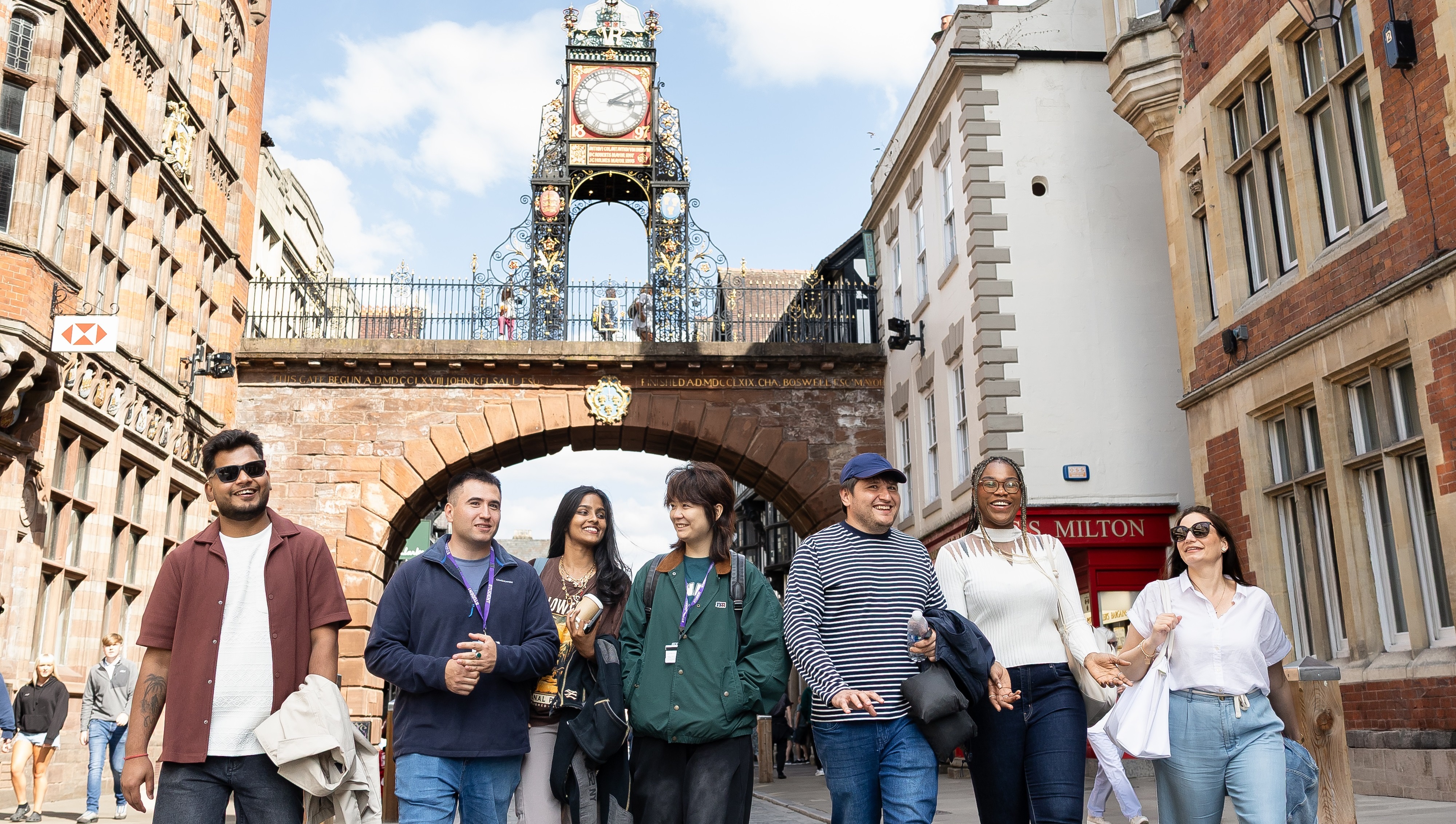 International students walking in Chester City Centre in front of the Eastgate Clock