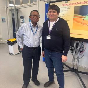 Khusan Gulomov (stduent) stood next to lecturer in front of a TV