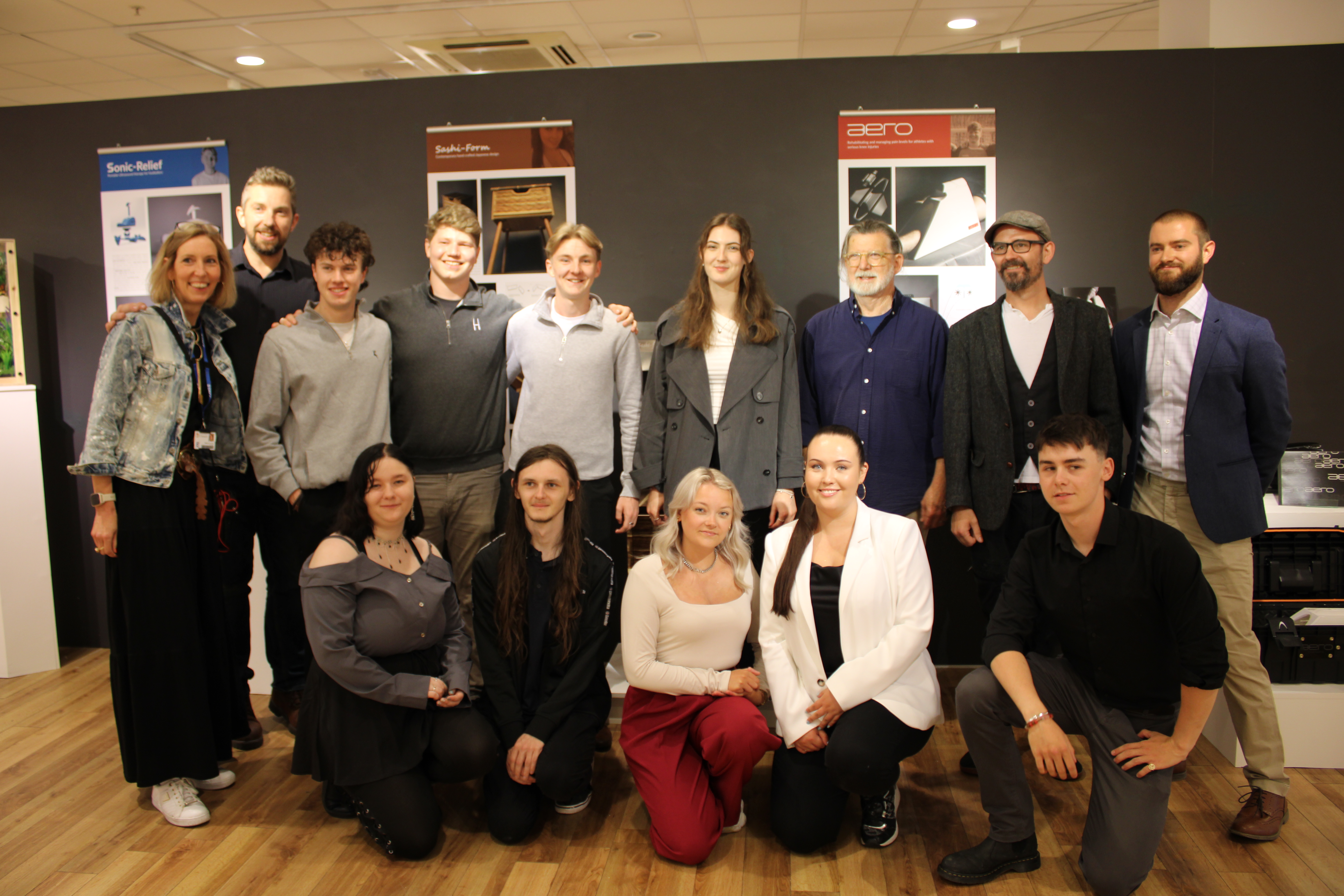 Product design students and lecturers smiling in group photo