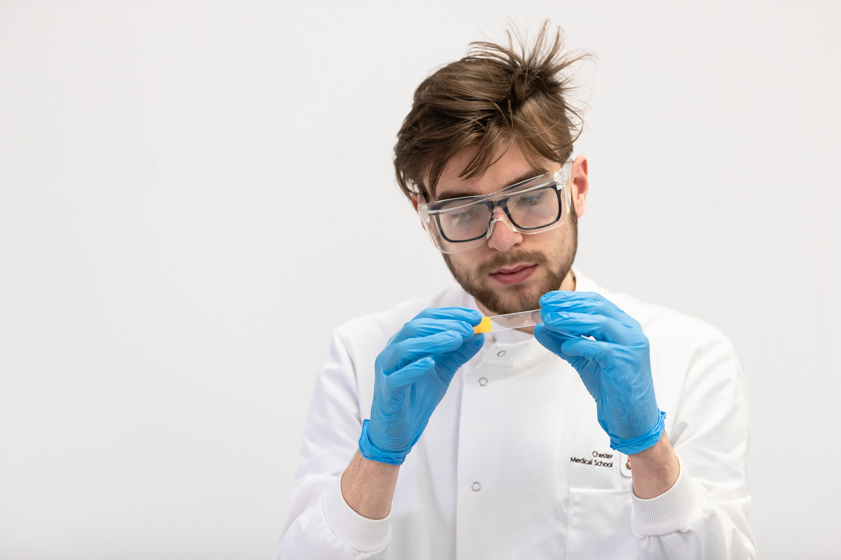 A man looking at test sample in biomedical science laboratory.