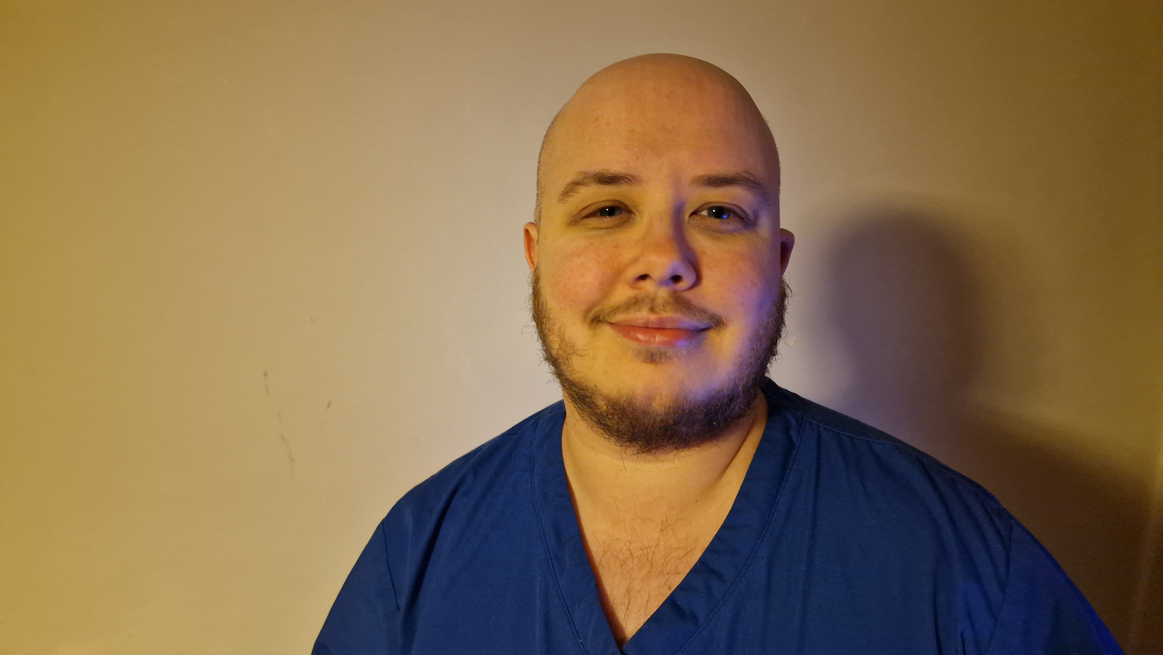 A student wearing blue Nursing scrubs