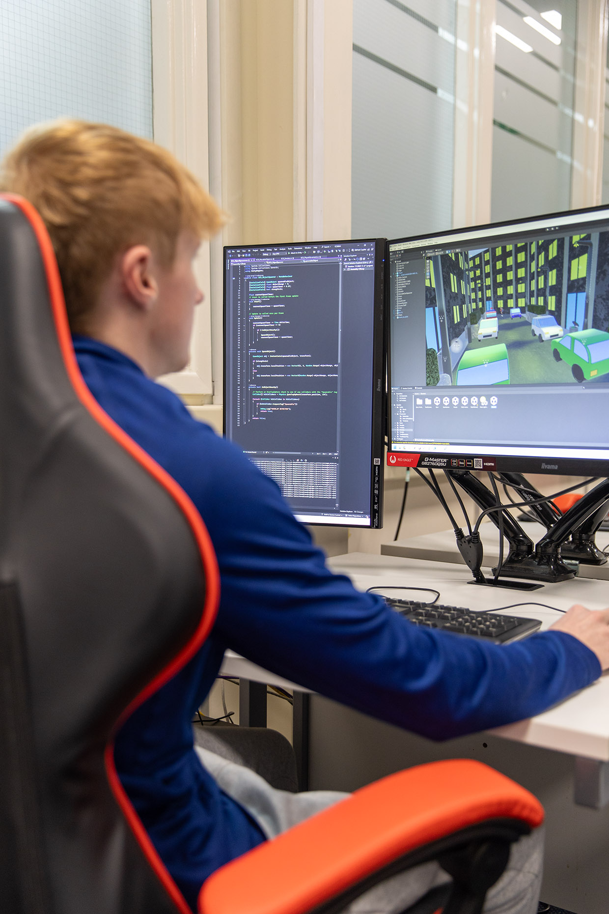 Student sat at a computer coding a game
