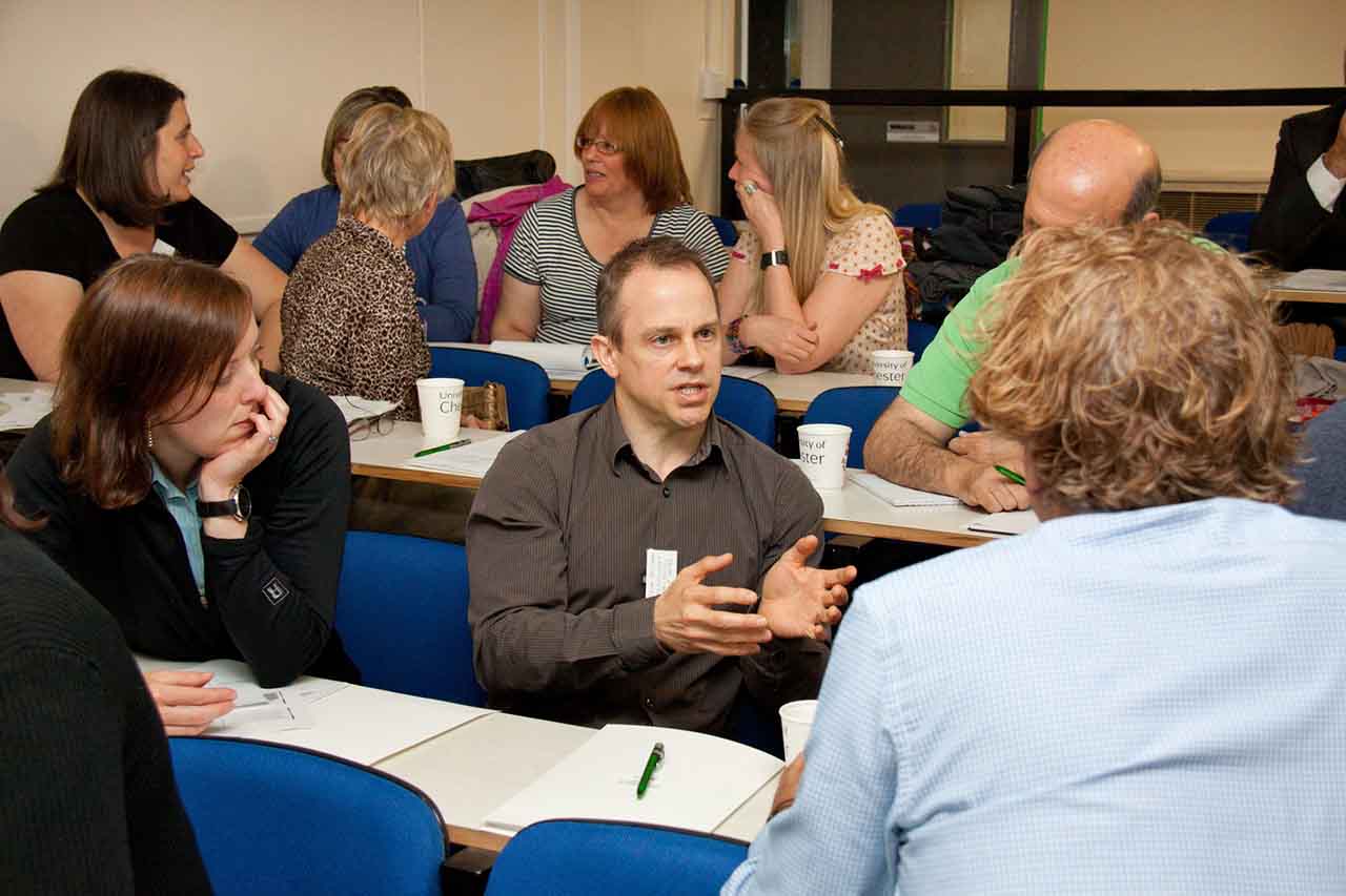 A group of people sitting in a room talking.