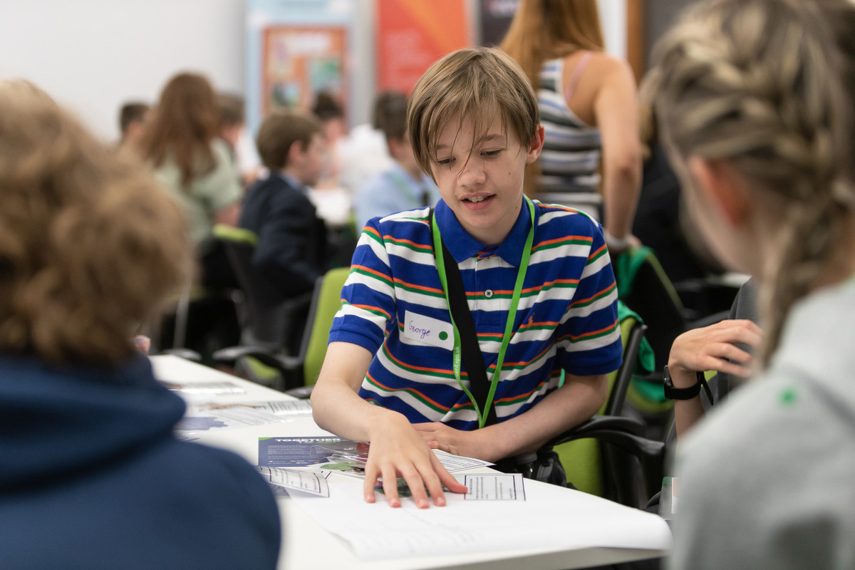 Young boy engaged in a group discussion.