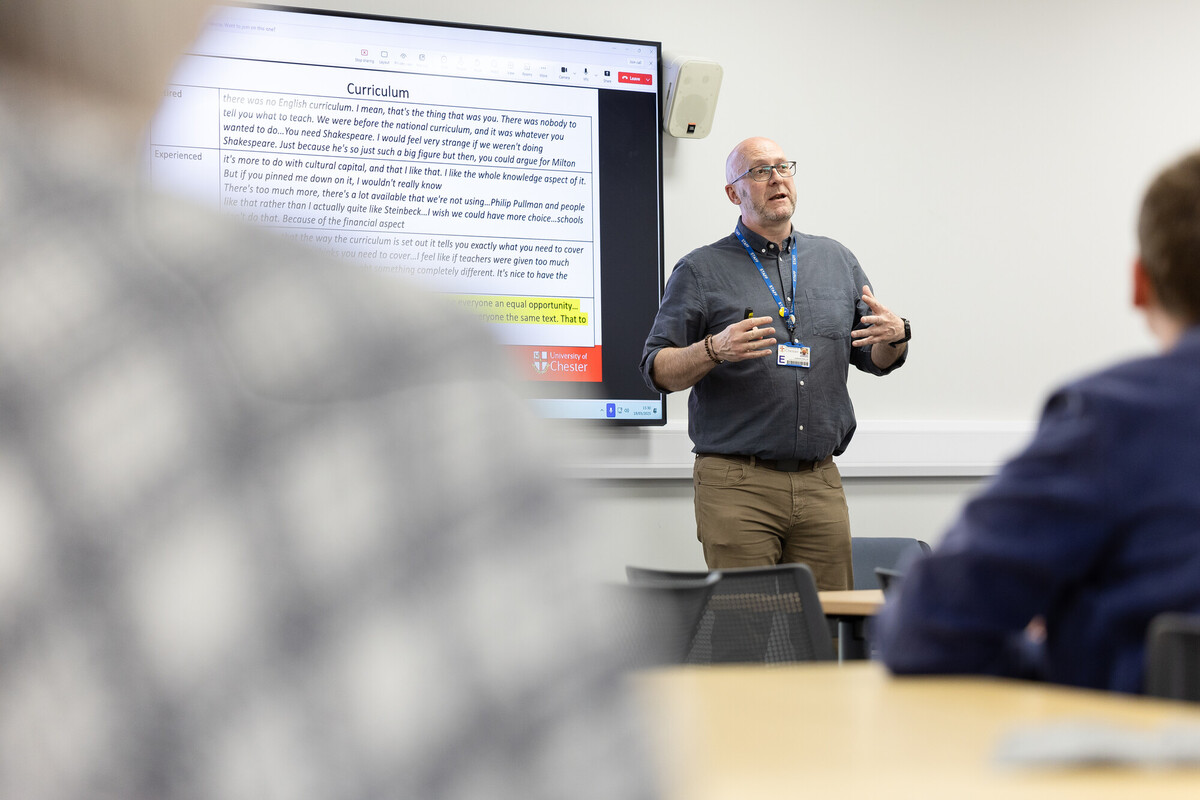 lecturer talking to students in classroom with presentation
