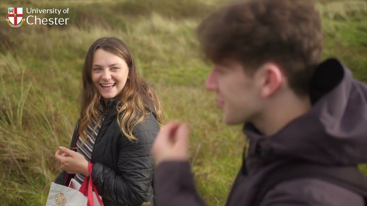 two students walking through a field