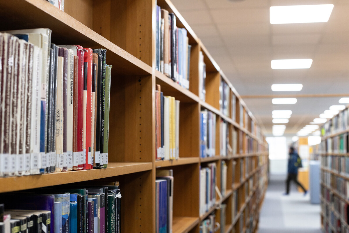 Library room with rows of book shelves with books.