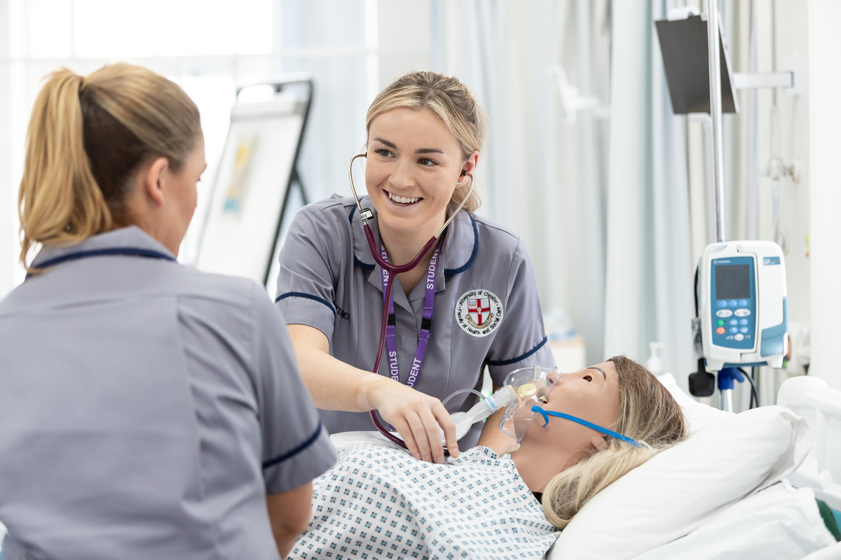 Student is using a stethoscope and smiling, indicating a positive and engaged learning experience.