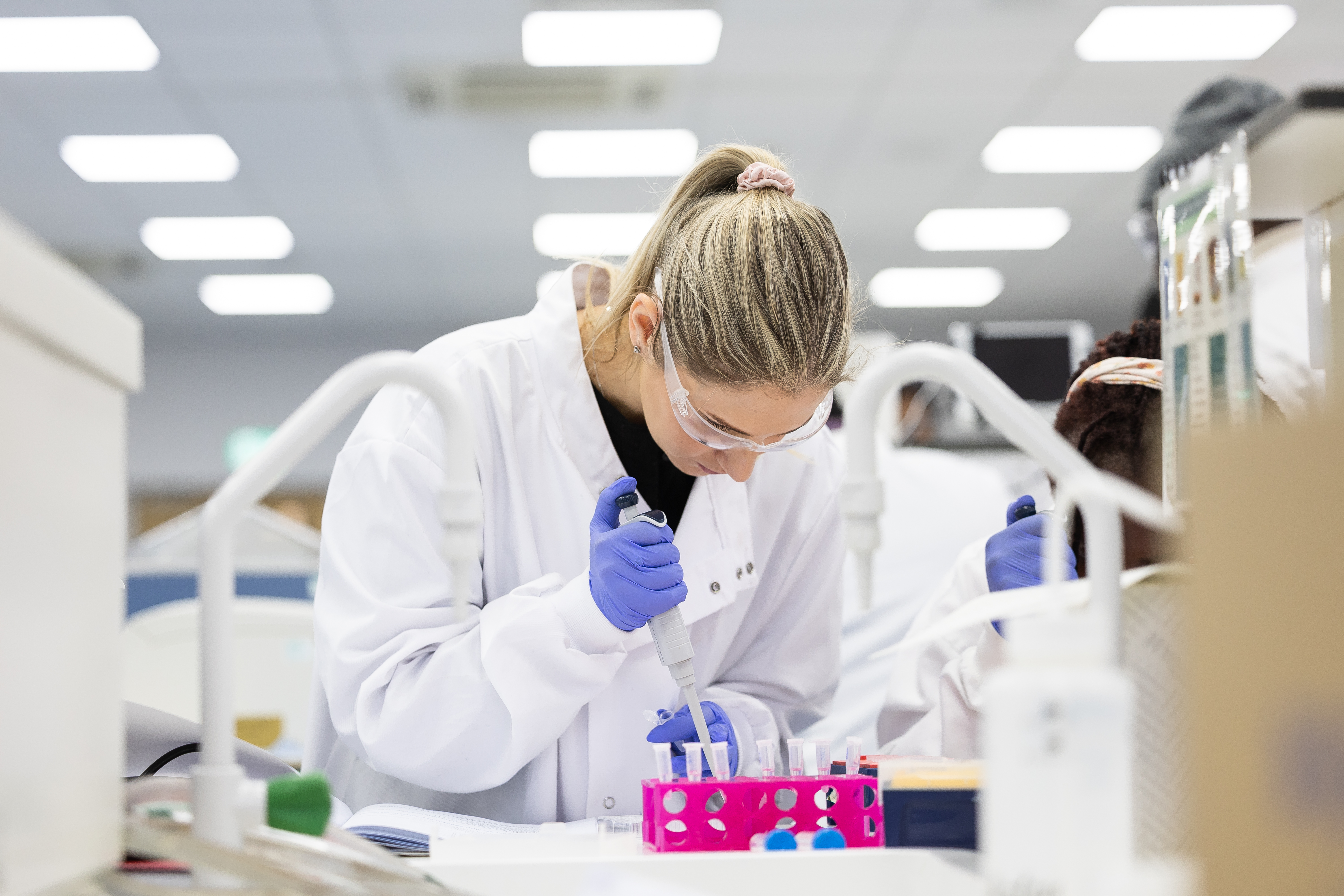 Biomedical student putting liquid in pods in the lab session