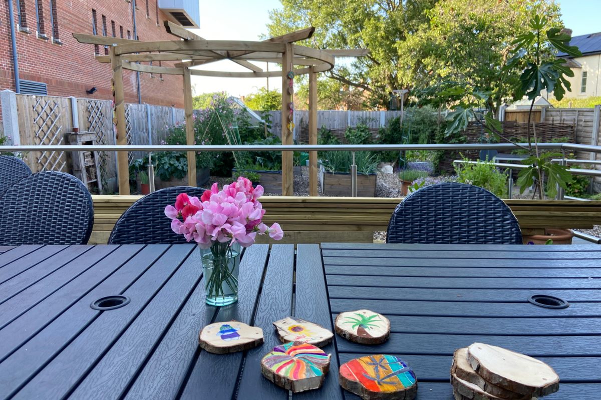 Crafts and flowers laid on a wooden table in the community garden.