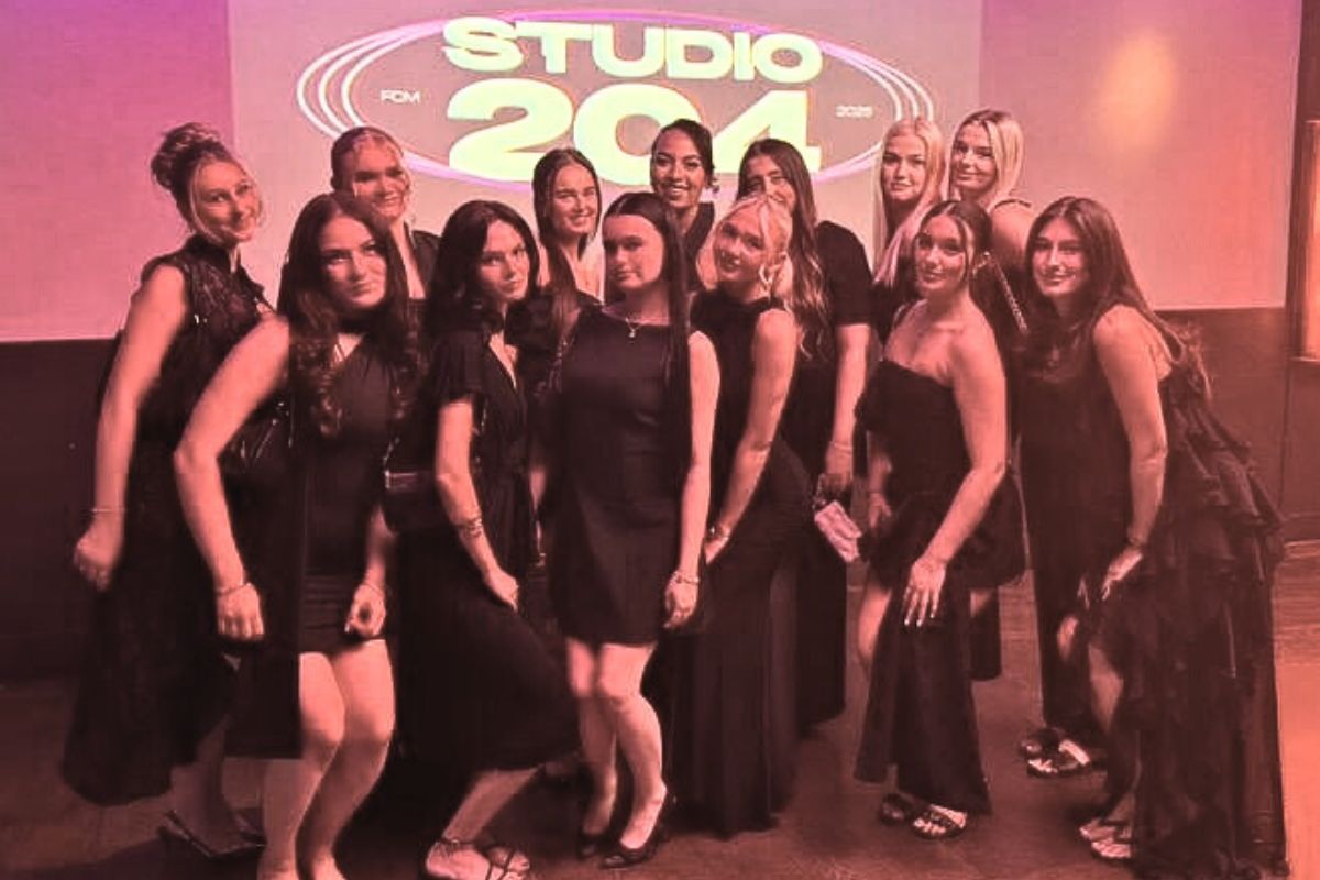 A group of women in dresses facing the camera