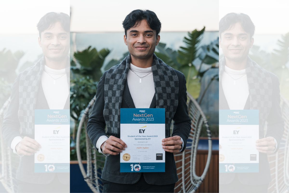 A photo of Aadhi looking at the camera while holding an award certificate which includes the text 'Student of the Year Award 2023 Sponsored by EY, Runner-up, Aadhi Agilan' at the NextGen Awards 2023