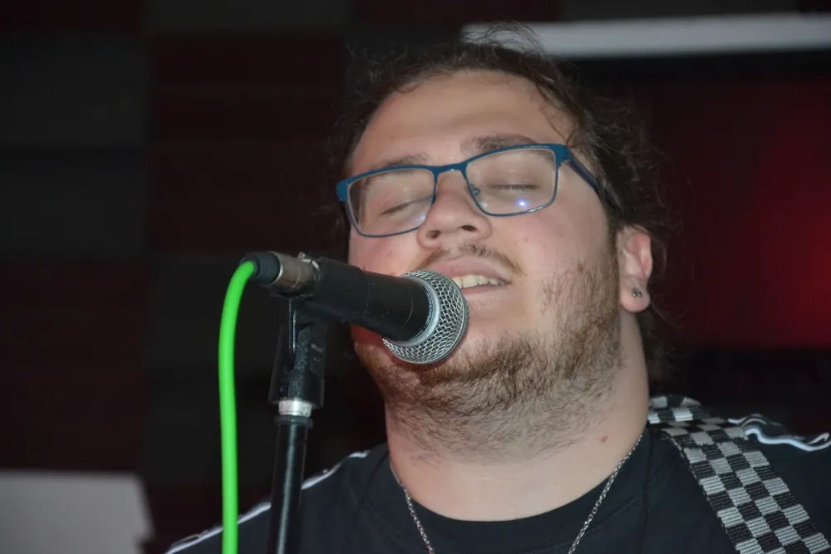 A singer with his eyes closed and a microphone in front of him.