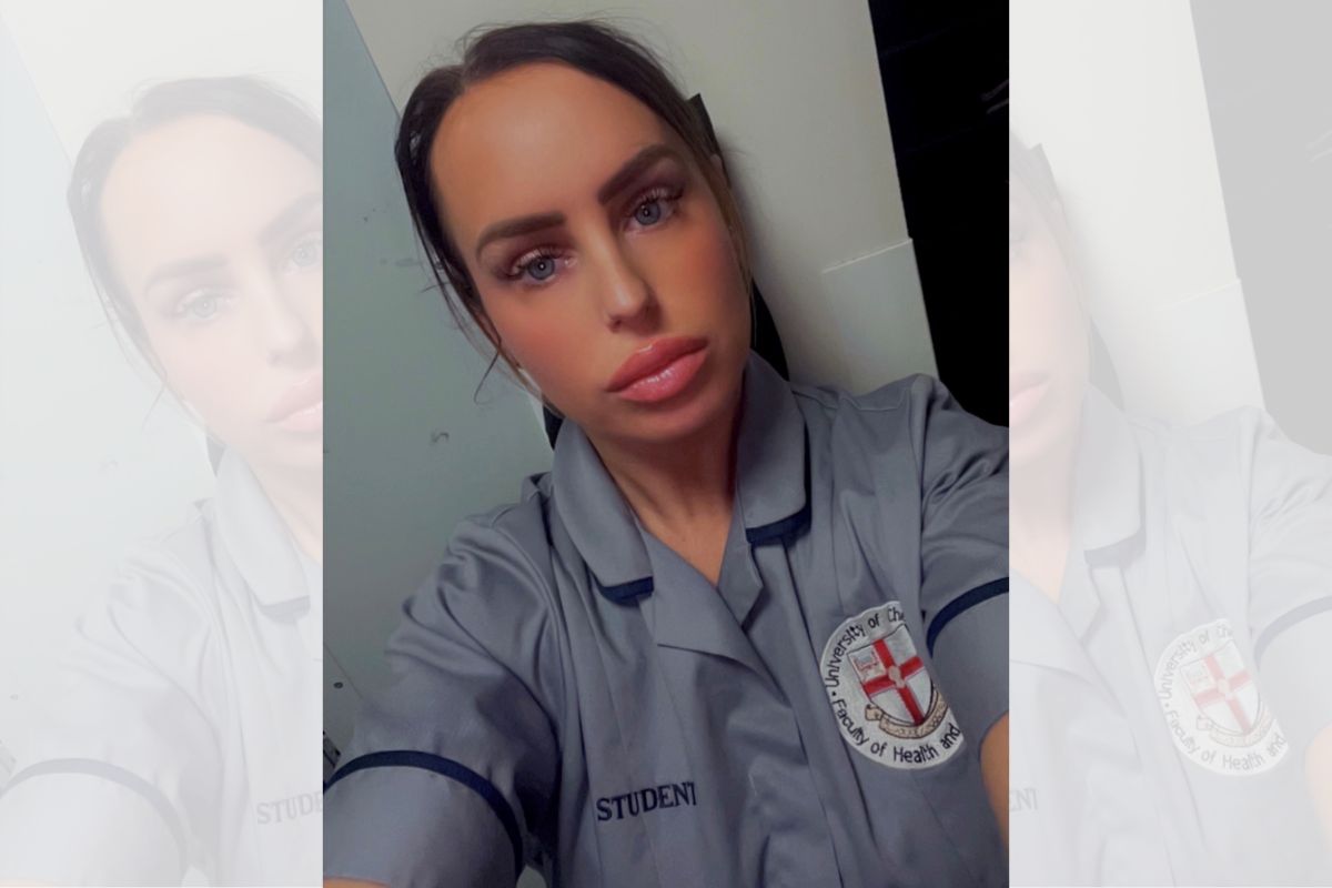 An angled selfie of a woman in student nursing uniform, looking at the camera.