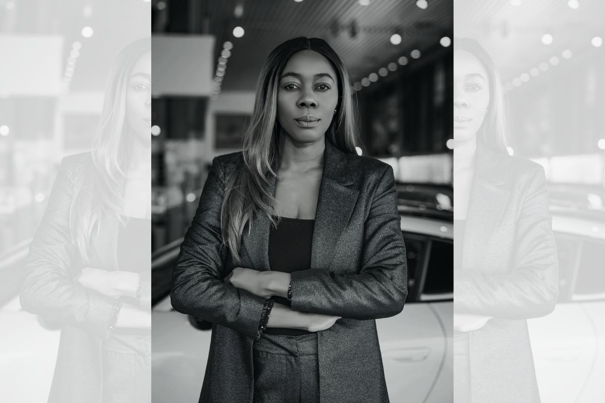 A black-and-white photo of Claire, arms folded, looking at the camera.
