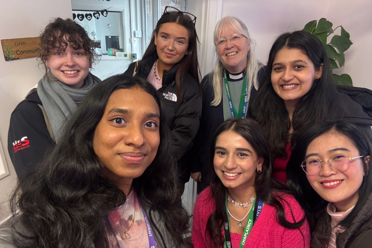 A group of seven women looking at the camera smiling.