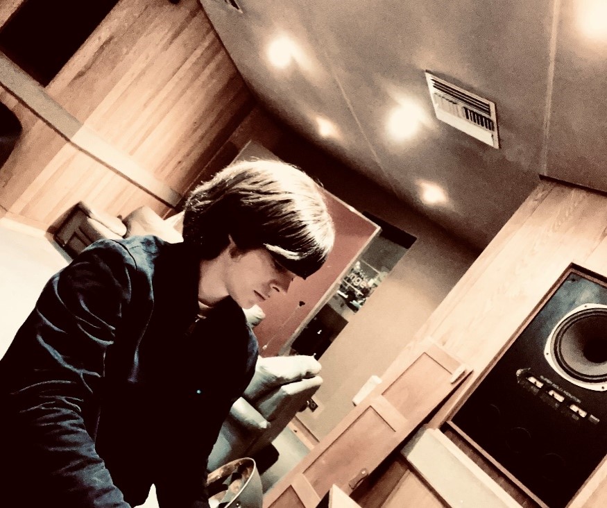 Student sat at a piano in a studio