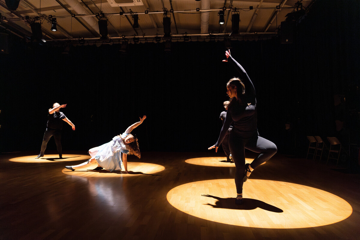 students posing in spotlights