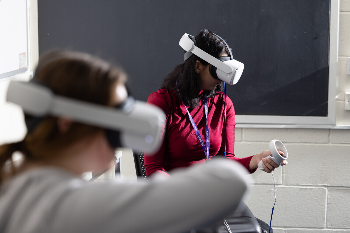 Two students using a VR headset during a Psychology equipement demo
