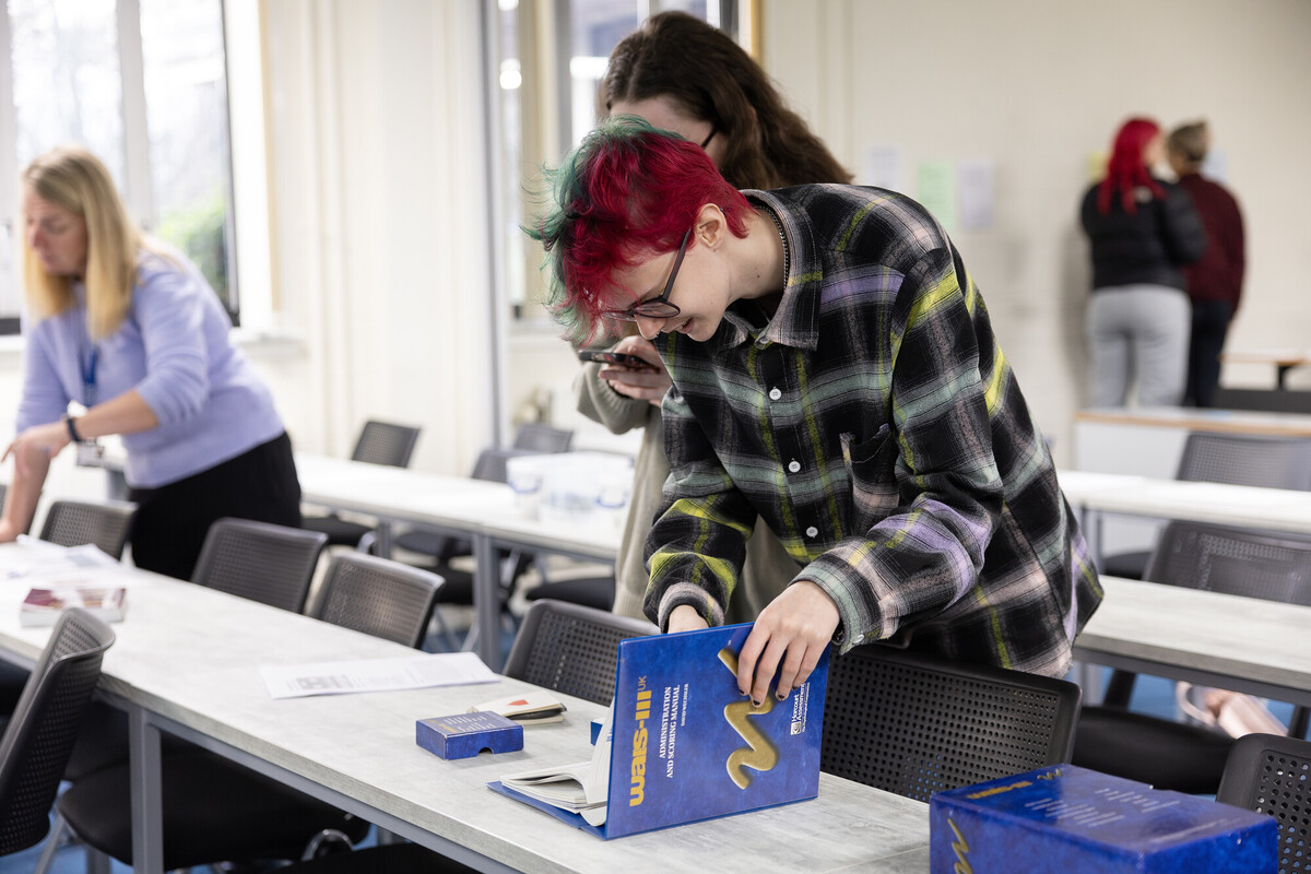 A psychology student looking at a folder on a desk