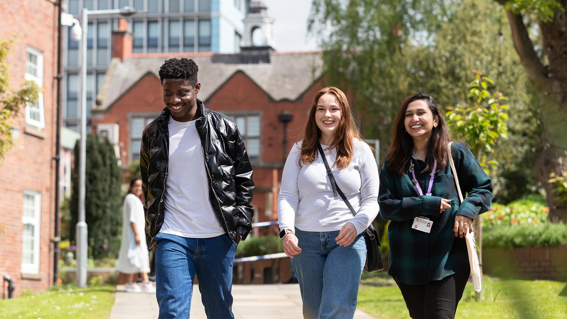 A group of students walking together outside at Exton Park campus. Buildings from campus are visible in the background.